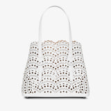 White handbag with floral cut-out design on a white background