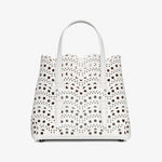 White handbag with black polka dot pattern on a white background