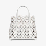White handbag with black polka dot pattern on a white background