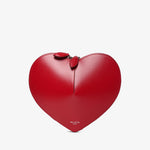 Red heart-shaped handbag with a bow on a light gray background