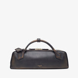 Black leather handbag with gold accents on a light gray background