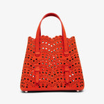 Red perforated handbag on a white background