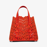 Red perforated handbag on a white background