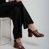 Person wearing a black outfit with brown shoes on a white background