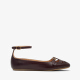 Brown leather flat shoe with a strap on a white background