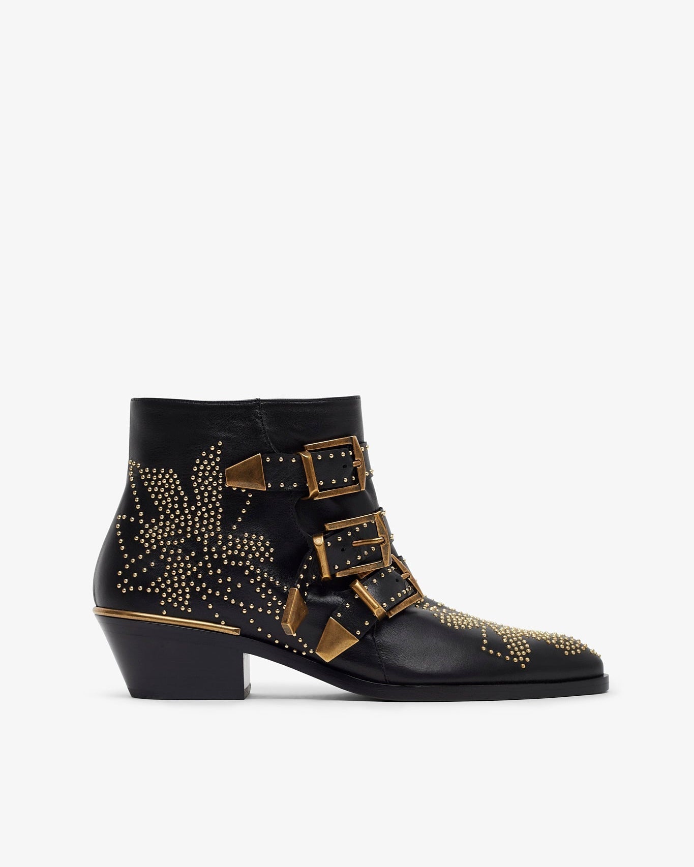 Black ankle boot with gold buckles and studs on a white background
