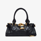 Black handbag with gold accents on a white background