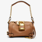 Tan handbag with gold accents on a white background