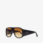 Black sunglasses with gold gradient lenses on a white background