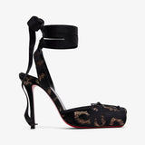Black high-heeled shoe with floral lace design on a white background