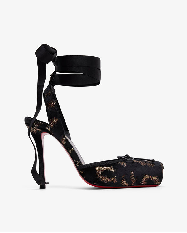 Black high-heeled shoe with floral lace design on a white background