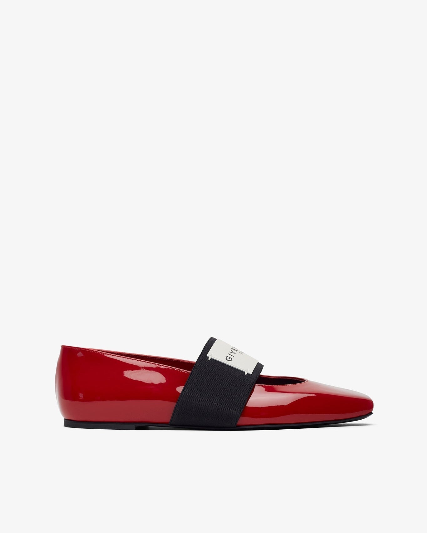 Red patent leather flat shoe with a black strap on a white background