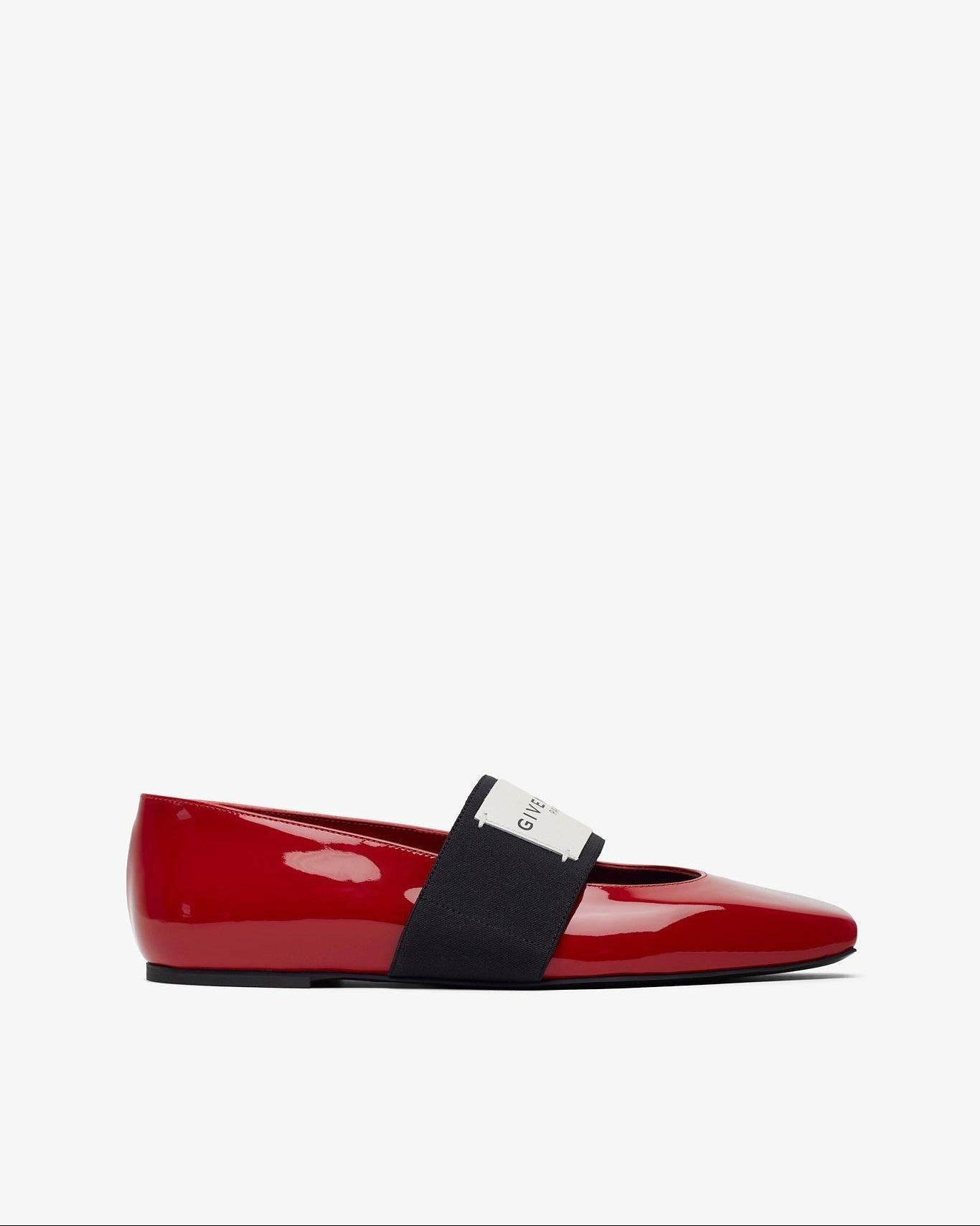 Red patent leather flat shoe with a black strap on a white background