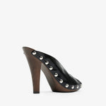 Black high-heeled shoe with studded details on a white background
