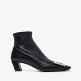 Black ankle boot with a small silver detail on a white background
