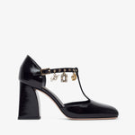 Black patent leather shoe with gold accents on a white background