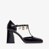 Black patent leather shoe with gold accents on a white background