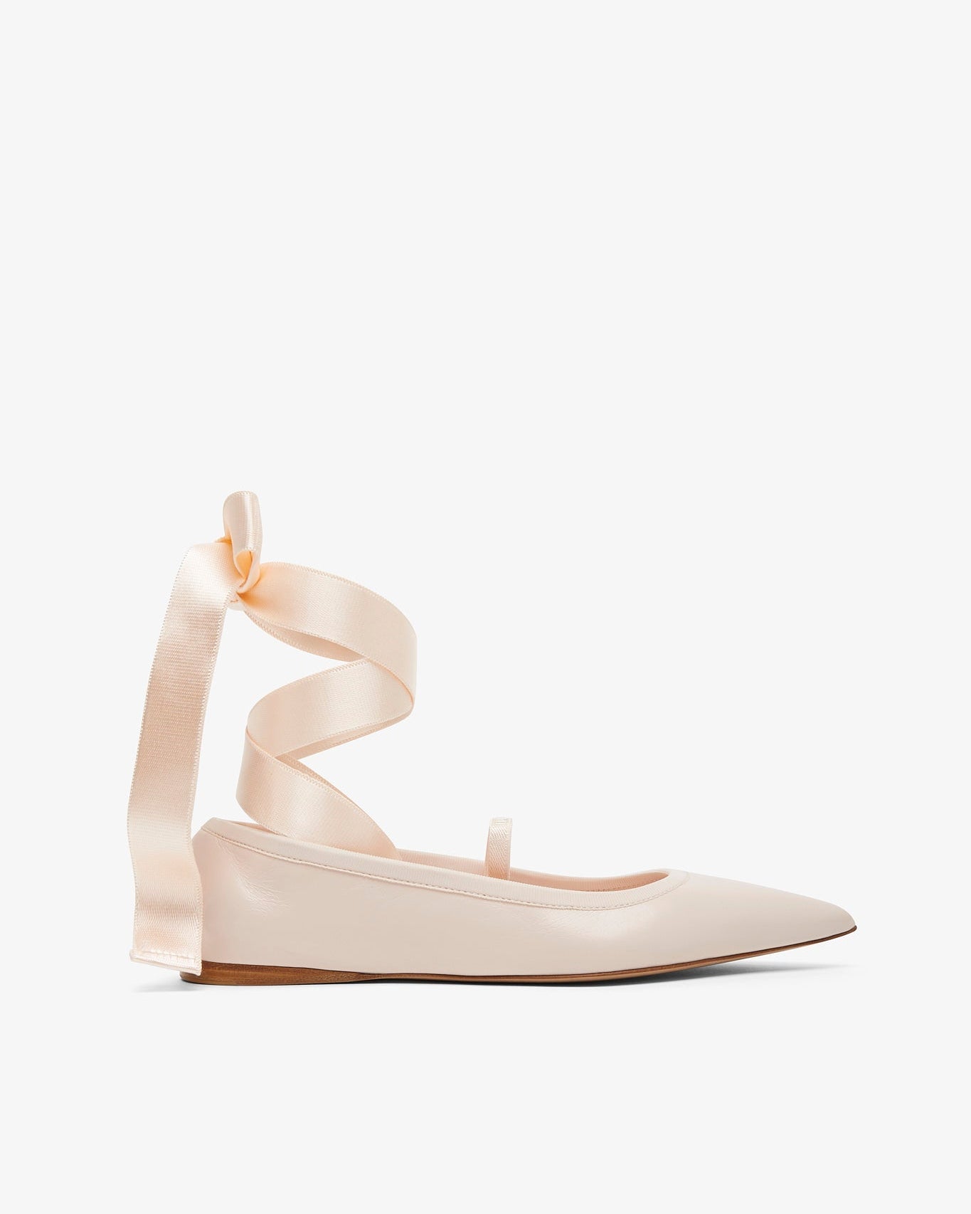Beige ballerina shoes with ribbon straps on a white background