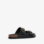 Black sandal with gold buckles on a white background