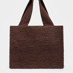 Brown woven tote bag on a light gray background