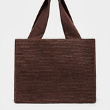Brown woven tote bag on a light gray background